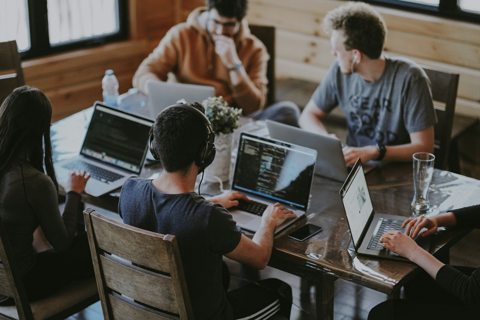 Team al lavoro intorno a un tavolo con computer portatili